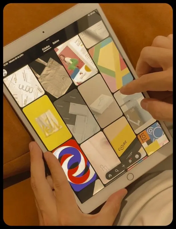 Mãos navegando por um tablet com uma grade de identidades visuais